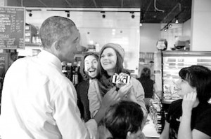 President Obama looks at a selfie with restaurant staff at Charmington’s Café in North Baltimore, Md., on Jan. 15. The president stopped at the restaurant to promote his proposal to guarantee paid sick leave for American workers.  (Pete Souza/The White House