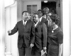 Dr. Martin Luther King Jr., surrounded by other civil rights leaders and aides leaves the West Wing after a meeting
with President Lyndon B. Johnson on Aug. 5, 1965, in preparation for Johnson’s signing of the Voting Rights Act
the next day. King then led the movement toward economic justice, but assassination took his life.

Photo courtesy of National Archive and Records Administration/WhiteHouse.gov