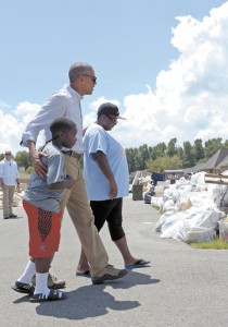 President Barack Obama walks with a family to our their flood-damaged home in the Castle Place neighborhood of Baton Rouge, La., Aug. 23, 2016.