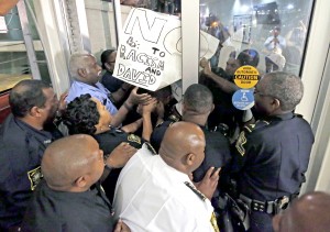 Police keep protesters from pushing through an auditorium door on Dillard University's campus which hosted a U.S. Senate debate at which former Ku Klux Klan leader David Duke participated.