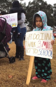 Three-year-old Sofia Magdalena stands outside Einstein Charter Schools with her mother at a protest in favor of providing yellow bus service. Her brother attends one of Einstein's elementary schools.